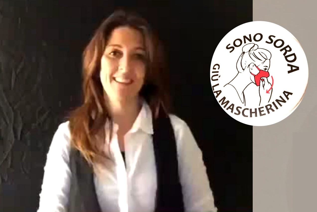 La spilla: «Siamo sordi, giù la mascherina»