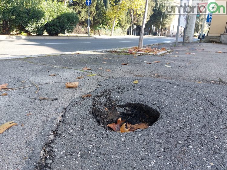 Una buca su un marciapiede